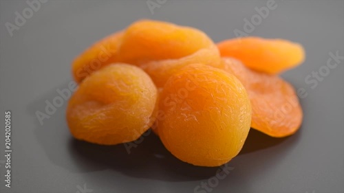 Dried apricots close-up. Apricot dried fruits on dark grey background. heap of ripe organic apricots fruit rotating. Close up. Vegan food, fiber. Dieting concept. 