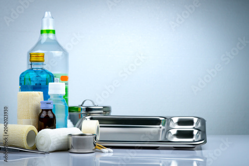 Schilderij op canvas Wound care dressing set and stainless steel plate, forceps, iodine cup, conform bandage, elastic cohesive retention bandage, antiseptic and normal saline bottle, instruments container