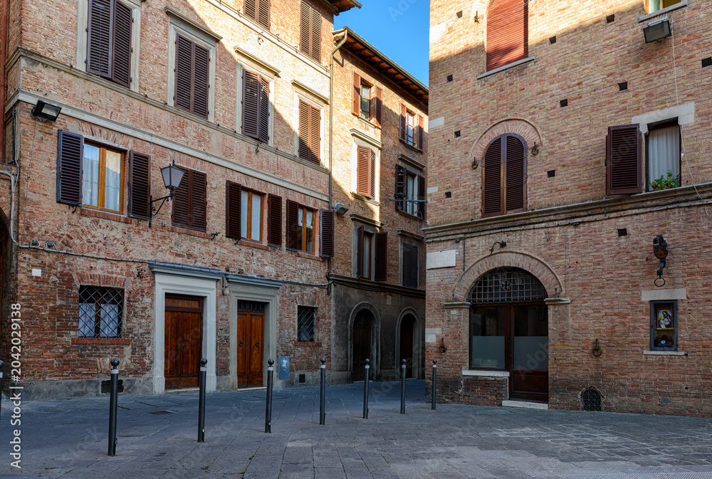 Fototapeta premium Medieval small square in Siena, Tuscany, Italy. Architecture and landmark of Siena. Cozy cityscape of Siena