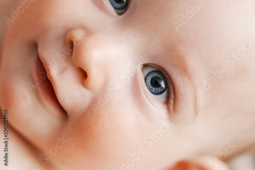 Extreme macro shot of a beautiful baby blue eye and gentle smile