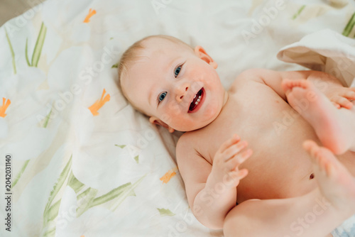 Happy Baby Boy Lying and Playing with Feet