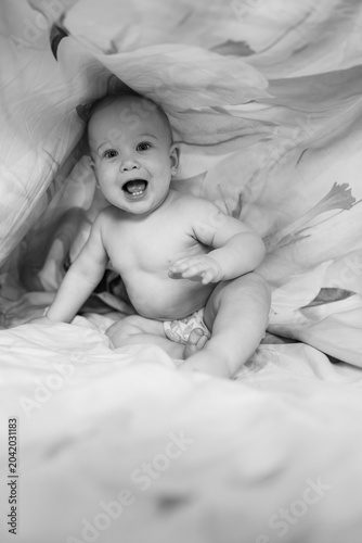Black and White Portrait of Baby Playing Under Sheet