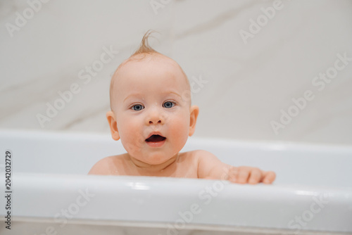 Curious Baby Looking Out of the Bathtub