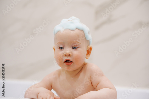 Portrait of a Curious Baby with Soap Bubbles on Head