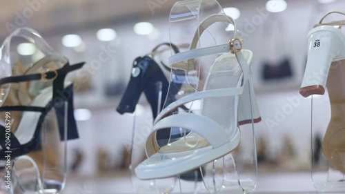 Stylish women's footwear collection with elegant high heel sandals on display stands in a retail shop window, showcasing the latest fashion trends for sale in a modern boutique showroom
