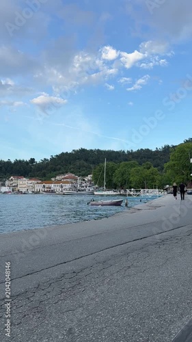 Traditional wooden boat moored by the shore on a peaceful Greek island, crystal clear sea, natural coastal scenery, calm Mediterranean atmosphere