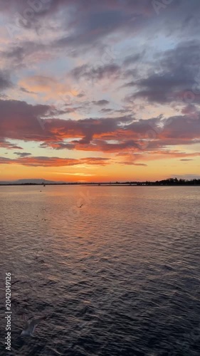 Stunning sunset over the ocean with a vibrant orange sky and deep blue sea