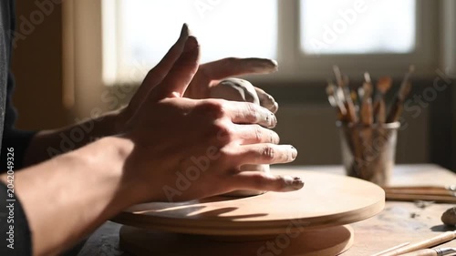 Hands shaping clay on a pottery wheel creating a ceramic art piece.