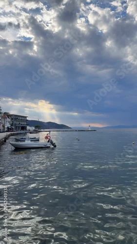 Traditional wooden boat moored by the shore on a peaceful Greek island, crystal clear sea, natural coastal scenery, calm Mediterranean atmosphere