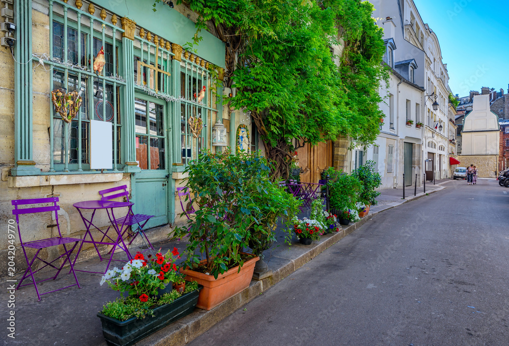 Obraz premium Typical view of street with tables of cafe in Paris, France. Cozy cityscape of Paris. Architecture and landmarks of Paris.