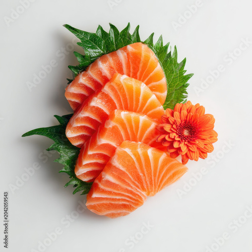 Freshly sliced salmon sashimi arranged green leaf with orange