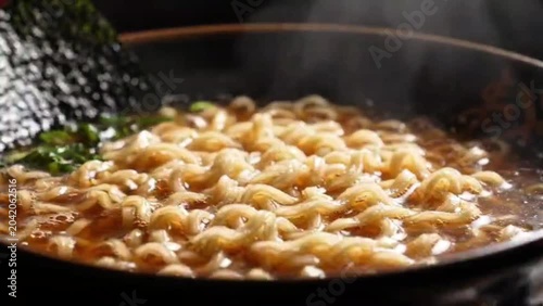 Steaming bowl of delicious ramen noodles with seaweed, a comforting and savory Japanese dish perfect for a cold day