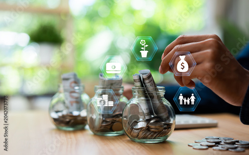 Фотография Young man saving money in glass jars with digital finance icons representing investment, insurance, healthcare and family protection
