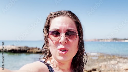 Enthusiastic Vlogger Capturing Beach Moments at Vouliagmeni Lake.