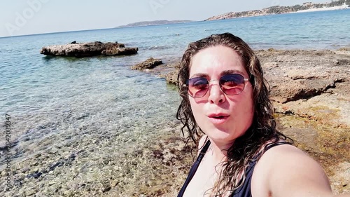 Happy Woman Vlogging Her Sunny Beach Day at Vouliagmeni.