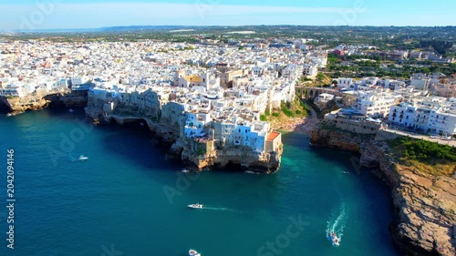 Polignano a Mare - Italy, Apulia - sideways circling aerial view around the houses by the sea