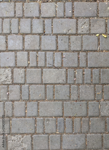 Top-down view of gray cobblestone pavement forming a geometric urban texture.
