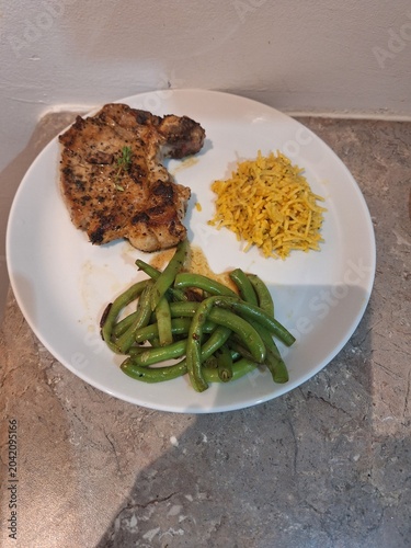 pork slice with green beans and rice in a plate