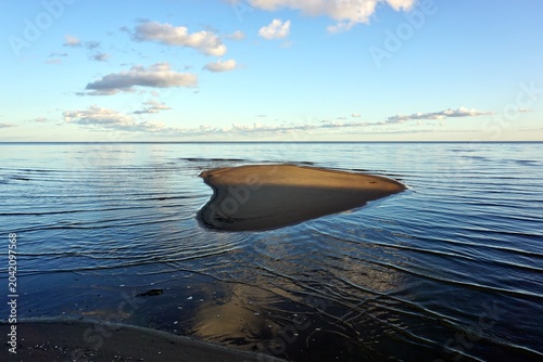 Foto heart shaped sandbar in the calm lake under blue sky