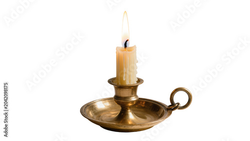 Burning candle in antique brass candlestick with drip marks