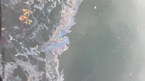 Colorful oil slick creating a rainbow pattern on the polluted water surface