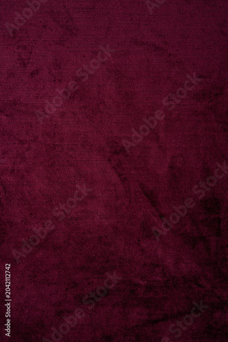 Dark red crushed velvet texture background, luxury burgundy velour fabric with soft shiny pattern.