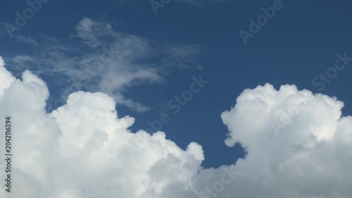 Puffy clouds moving across blue sky timelapse