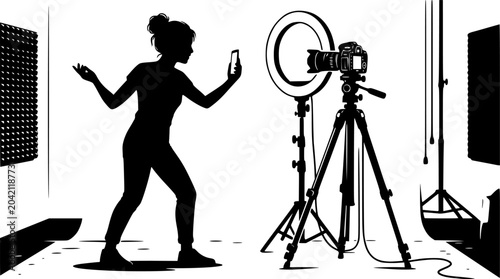 Silhouette of young woman recording video on smartphone with ring light and camera on tripod in studio setting for social media content creation

