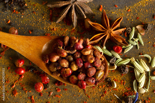 Spices and seasoning in a spoon on a black background