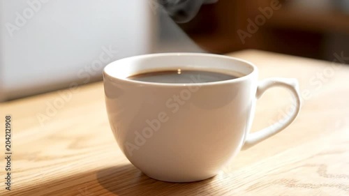 Steaming White Coffee Mug on a Wooden Table in Soft Sunlight with Subtle Bokeh