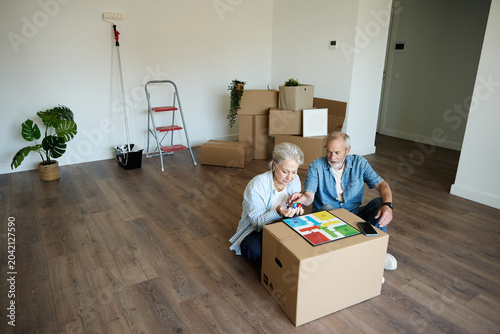 Photography Senior couple relaxing on floor in new apartment