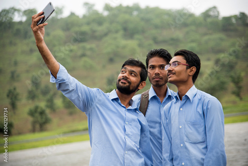 Foto Young Indian People taking a selfie with Smartphone at outdoors.