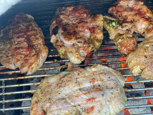 Foto Gegrillte Fleischstücke auf einem heißen Grillrost mit steak deutlichen Grillstreifen