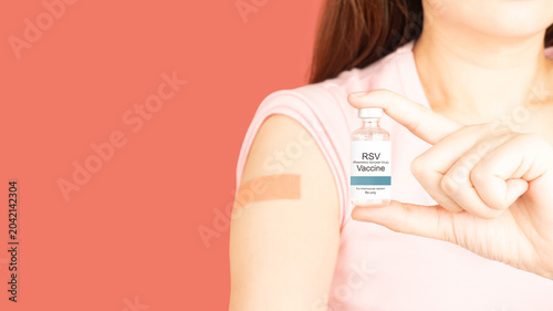 Bild auf Leinwand Woman showing vaccinated arm with medical adhesive bandage strip after RSV vaccine injection over pink background that protect pregnancy woman and infants from respiratory tract diseases