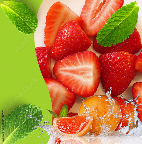 Fresh sliced strawberries and orange with mint leaves and water splash on green background 