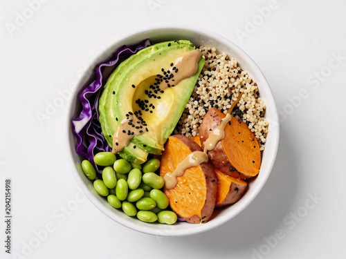 Overhead view of a healthy vegetarian grain bowl with sesame dressing isolated on white