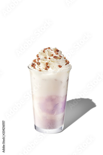 45 degree angle shot of layered taro paste milk beverage topped with whipped cream, isolated.