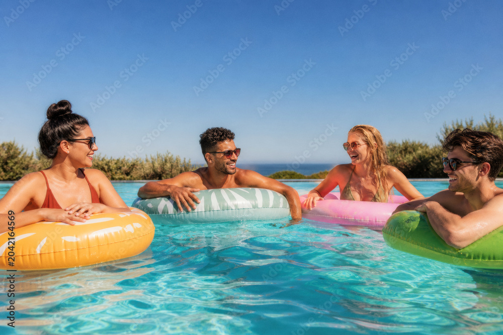 Obraz premium Friends enjoying a sunny day in a swimming pool