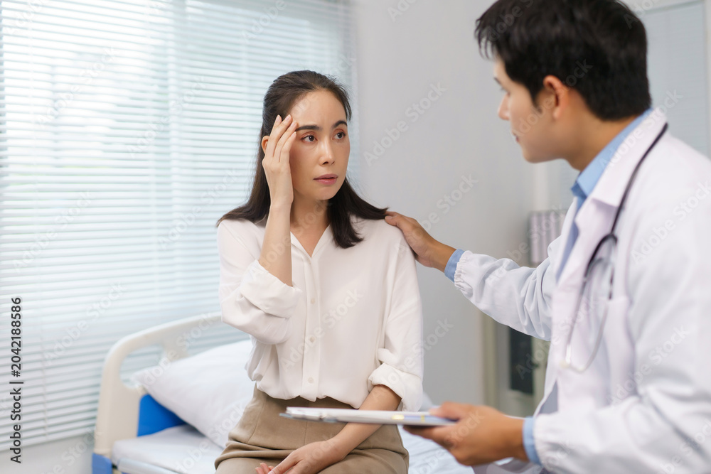 Fototapeta premium Doctor offering comfort and support to a female patient feeling unwell, experiencing pain or stress during a healthcare visit