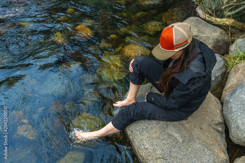 Fotografija Woman relaxing in cold stream water on a summer day