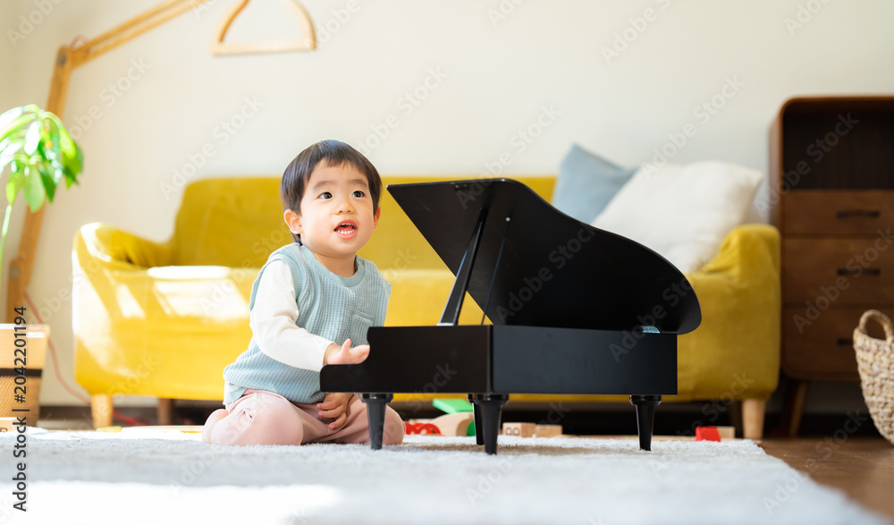 Φωτογραφία リビングでおもちゃのピアノを弾く3歳の男の子