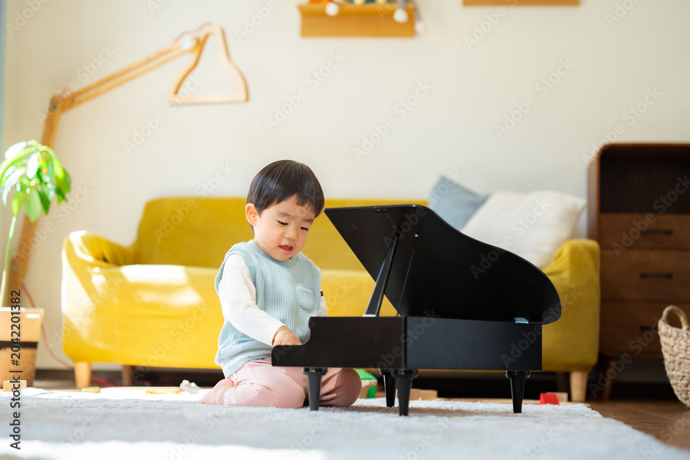 Φωτογραφία リビングでおもちゃのピアノを弾く3歳の男の子