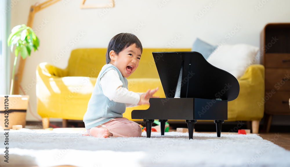 Φωτογραφία リビングでおもちゃのピアノを弾く3歳の男の子