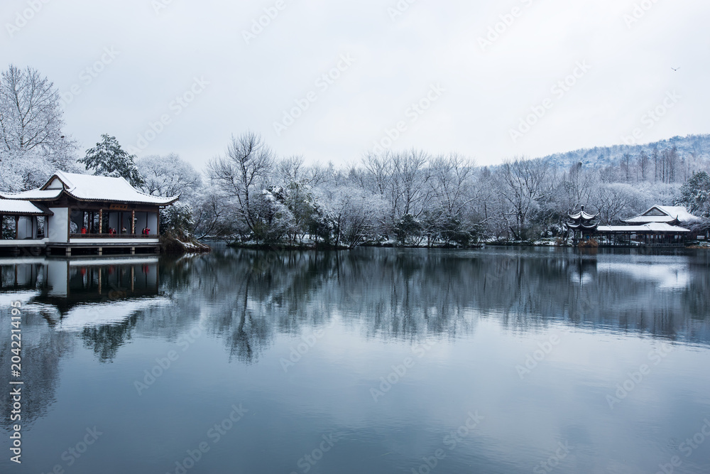 Fototapeta premium Snowy West Lake pavilions reflected on calm water in Hangzhou