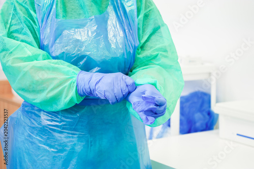 A dedicated medical professional carefully puts on sterile blue nitrile gloves in a clinical setting to ensure safety and hygiene while preparing for essential health procedures