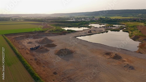 Birds eye drone image of a quarry operation displaying sand heaps, open pit mining areas and processing facilities essential to the construction supply chain