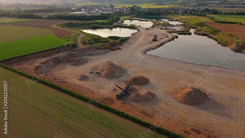Elevated aerial view of a German aggregate plant with excavation sites, conveyor belts and stockpiles supporting concrete manufacturing and civil engineering projects