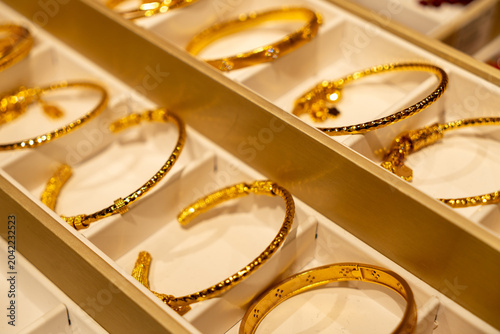 Foto Display of various gold bangles in a jewelry store showcase