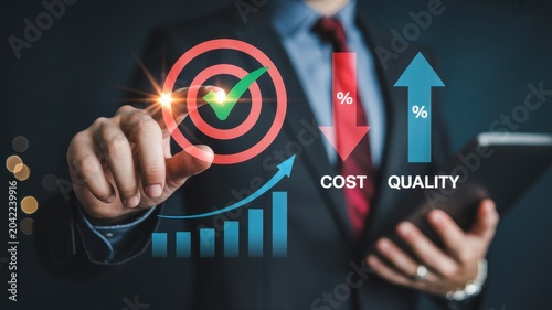 Businessman pointing at target with checkmark symbolizing success and growth in cost reduction and quality improvement.