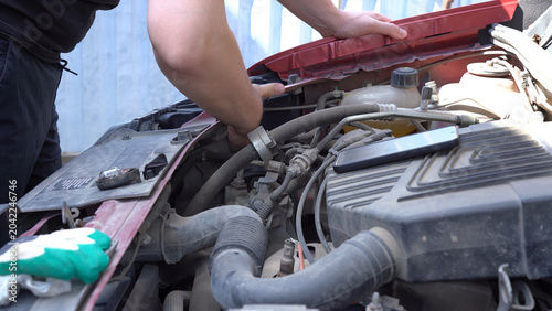 Konstfotografi A Person Working on a Car Engine, Diagnosing Issues and Performing Maintenance w
